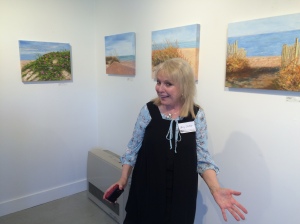 The artist, Nancy E. Custin, with her paintings at DeBlois Gallery, Middletown, RI